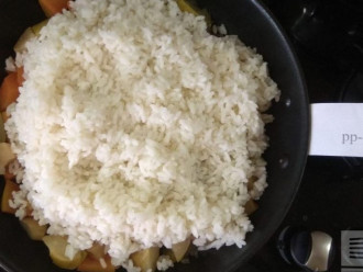 Шаг 6: Сверху выложите вареный рис и прогрейте смесь. По желанию добавьте 1 столовую ложку сливочного масла - это не даст склеиваться рису. Я обошлась без масла.