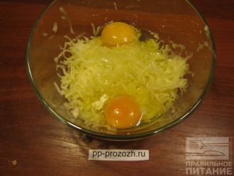 Шаг 2: Натрите кабачок на крупной терке и добавьте к нему 2 яйца. Перемешайте.