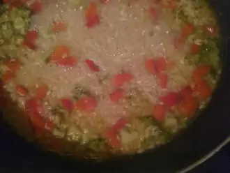 Шаг 5: Добавьте бульон от кальмаров, если нужно подсолите оставшейся солью. Тушите до готовности риса, если нужно добавьте немного воды.