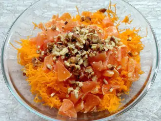 Шаг 6: Выложите в миску натертую морковь, порезанный апельсин и измельченные грецкие орехи.