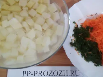 Шаг 3: Картофель и лук порежьте кубиками. Морковь потрите на терке, петрушку измельчите.