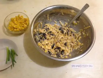 Шаг 7: Выложите сыр, чернослив, орехи, чеснок и часть кукурузы  в миску. Добавьте майонез и перемешайте.