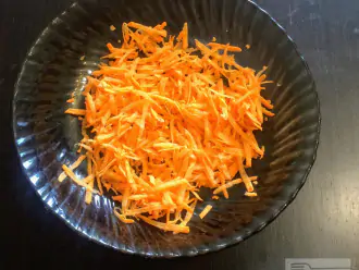 Шаг 2: Морковь очистите и натрите на терке. Выложите в глубокую миску.