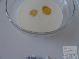 Шаг 3: Влейте в миску молоко, разбейте 2 яйца и хорошо взбейте венчиком. 