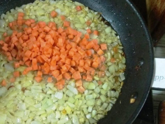 Шаг 3: Влейте в сковороду небольшое количество масла и добавьте лук, затем морковь. Спассеруйте овощи до мягкости.