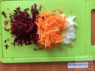 Шаг 2: Морковь и свёклу натрите на крупной терки, а лук нарежет тонкими полукольцами.