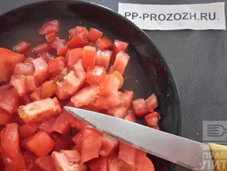 Шаг 4: Нарежьте мелко помидор. Разогрейте сковороду, капните туда масло и выложите овощи тушиться.