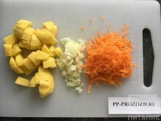 Шаг 2: Почистите, помойте, нарежьте кусочками картофель. Лук порежьте мелко, морковь натрите на терке.