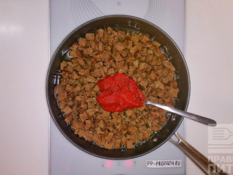 Шаг 5: Отваренное кусочками сердце переложите на сковороду желательно с тефлоновым покрытием. Добавьте воды, чтобы она не полностью покрывала кусочки мяса и 4 столовые ложки томатной пасты.