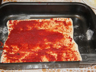 Шаг 4: Раскатайте пласт теста, смажьте томатной пастой, посыпьте отрубями, чесноком.