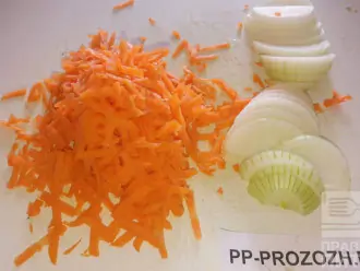 Шаг 4: Потрите морковь на крупной терке и нарежьте лук кольцами и добавьте где-то через 40 минут к говядине. 