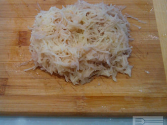 Шаг 3: Картофель натрите на мелкой терке и смешайте с луком.