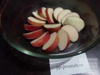 Шаг 2: Одно яблоко помойте, удалите семена и порежьте дольками. Выложите их на дно формы.