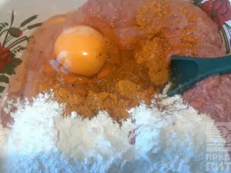 Шаг 3: В фарш добавьте специи (кари + хмели-сунели), яйцо и муку и измельченные сухари. Все перемешайте как следует.