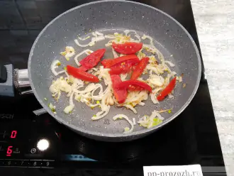 Шаг 4: Нарежьте помидор дольками и добавьте в сковороду к луку. 