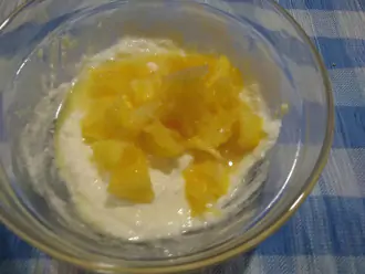 Шаг 4: Нарезанный кусочками апельсин вместе с тертой цедрой и соком добавьте в творог.

