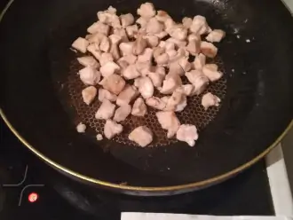 Шаг 3: Добавьте на сковородку оливковое масло и разогрейте. Куриную грудку порежьте на небольшие кусочки и обжарьте до золотистой корочки.