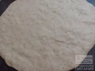 Шаг 6: Раскатайте тесто скалкой или растяните руками, сформировав основу для пиццы. 