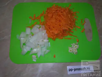 Шаг 2: Морковь, лук и чеснок почистите. Морковь натрите на терке, лук и чеснок нарежьте. Разогрейте антипригарную сковороду и выложите в нее нарезанные овощи. Протушите, с небольшим добавлением воды, 10 минут.