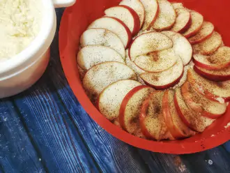 Шаг 9: Нарежьте яблоки. В форму выложите часть теста, сверху выложите яблоки и присыпьте их корицей. И вновь доложите тесто. Полученный пирог отправьте в духовку на 40 минут.