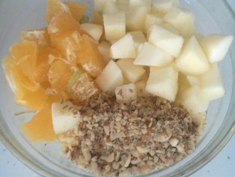 Шаг 6: Выложите в салатник сельдерей. Добавьте яблоко, грецкие орехи и кусочки апельсина.