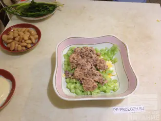 Шаг 4: Консервы без жидкости разомните вилкой и добавьте в салатницу.