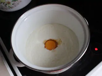 Шаг 6: Добавьте яйцо в остывший до +55℃ йогурт и аккуратно перемешайте вилкой.