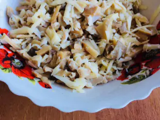 Шаг 3: Нарежьте мелко шампиньоны. Смешайте грибы с курицей, добавьте сыр и посолите.