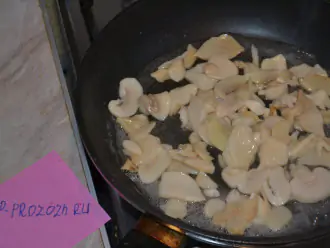Шаг 2: Шампиньоны (если у вас целые - нарежьте пластинками) выложите на сухую сковороду, потушите примерно 5-7 минут под крышкой, чтобы выпарилась лишняя жидкость.