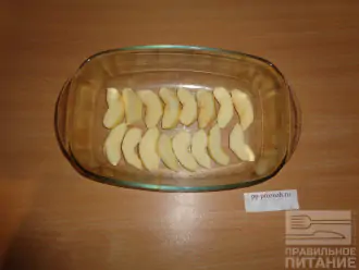 Шаг 2: Очистите и разрежьте яблоки дольками, толщиной 1-1,5 см и выложите на дно формы для запекания.