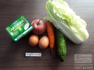 Шаг 1: Приготовьте необходимые ингредиенты: пекинскую капусту, яйцо, морковь, огурец, яблоко, натуральный йогурт. 