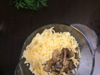 Шаг 6: Натрите сыр на крупной терке и добавьте к сыру жареные грибы.