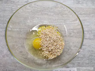 Шаг 2: Разбейте в миску яйца. Чуть присолите и добавьте обяные хлопья.