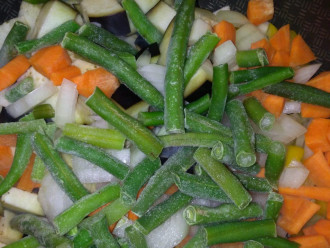 Шаг 4: Разогрейте антипригарную сковороду и всыпьте в нее болгарский перец, морковь, лук, фасоль и баклажан. Протушите, помешивая, 15 минут.