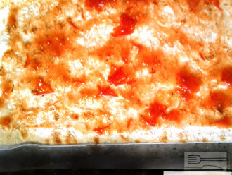 Шаг 2: От лаваша отрежьте один квадрат и смажьте томатным соусом. Это будет основа Вашей пиццы. Если хотите сделать ее более мягкой, то возьмите два таких квадрата из лаваша, промажьте соусом и посыпьте тертым сыром.