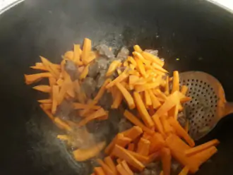 Шаг 4: Добавьте морковь порезанную соломкой и тоже потушите минут 5.