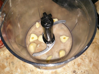 Шаг 3: Пока варятся макароны, в чашу блендера добавьте очищенный чеснок.