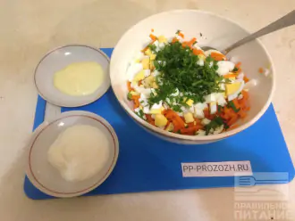 Шаг 4: Порежьте мелко петрушку, чеснок измельчите удобным способом. Добавьте петрушку и чеснок в салат.