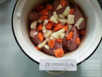 Шаг 5: В кастрюлю с толстым дном сложите мясо вперемешку с овощами. Но не добавляйте кабачок. Он готовится быстро, так что его добавите позже.