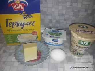 Шаг 1: Подготовьте все необходимые ингредиенты: геркулес, мягкий творог, яйцо, кефир и сыр.