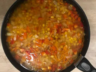 Шаг 6: Добавьте рис, кукурузу, специи и залейте водой. Накройте кружкой и готовьте 20-25 минут до полного испарения жидкости.