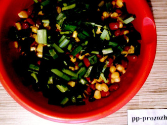 Шаг 4: Зеленый лук мелко нарежьте и добавьте в салат. Поперчите по вкусу.