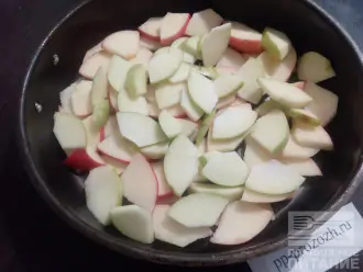 Шаг 2: Яблоки нарежьте тонкими дольками и разложите по дну формы, застланной пекарской бумагой.