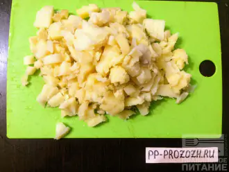Шаг 4: Вареный картофель мелко порежьте кубиками и уложите половину в форму.