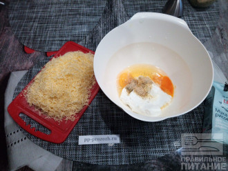 Шаг 2: Сыр натрите на мелкой терке. Соедините в миске творог, яйца и специи.