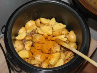 Шаг 6: Выложите картофель в чашу мультиварки и перемешайте с луком, добавьте красный перец и тушите с небольшим количеством воды 20 минут.