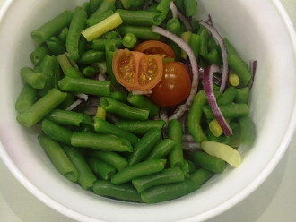 Шаг 6: В салатник выложите помидоры, лук и стручковую фасоль. Добавьте соус.