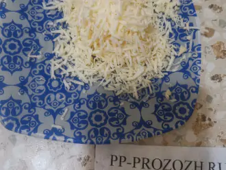 Шаг 3: Натрите сыр на мелкой терке и ровно половину добавьте к смеси.