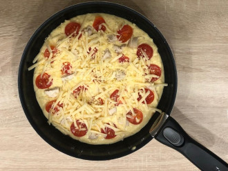 Шаг 7: Выложите на тесто помидоры, куриное филе и посыпьте оставшимся тертым сыром. 
Накрываете крышкой и готовите на медленном огне 5-7 минут.