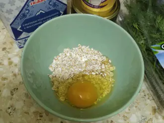 Шаг 2: В тарелку добавьте овсяные хлопья и яйцо.